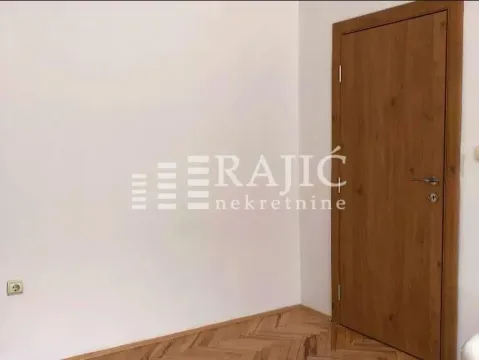Empty room with wooden doors and parquet flooring. - image 13