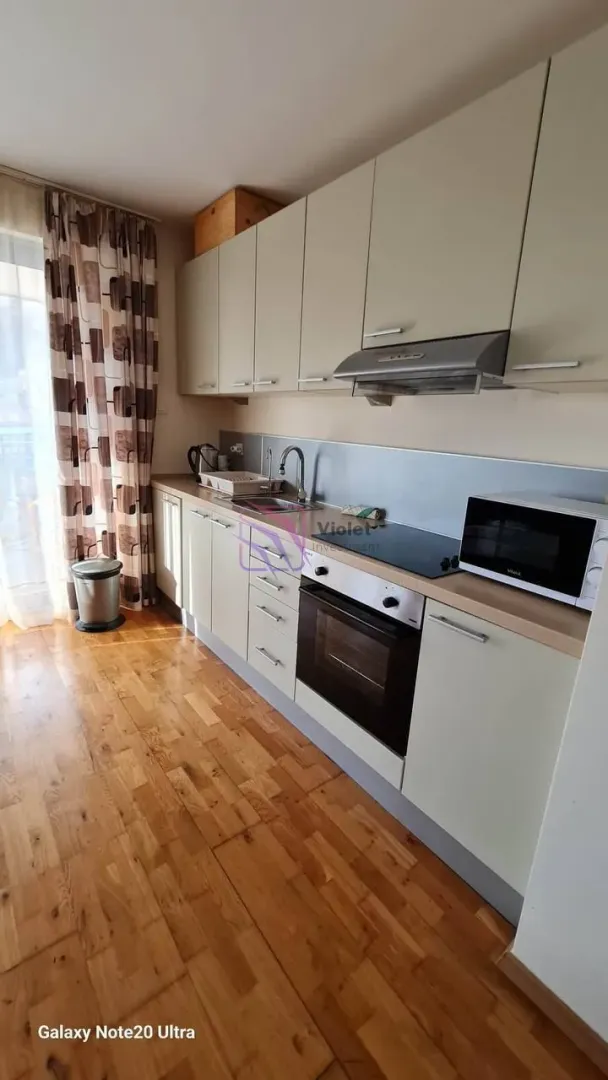 Kuhinja sa drvenim podom, donjim i gornjim elementima i ugrađenim aparatima.