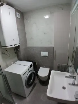 Moderno opremljeno kupatilo sa tuš kabinom, umivaonikom i veš mašinom. - image 7