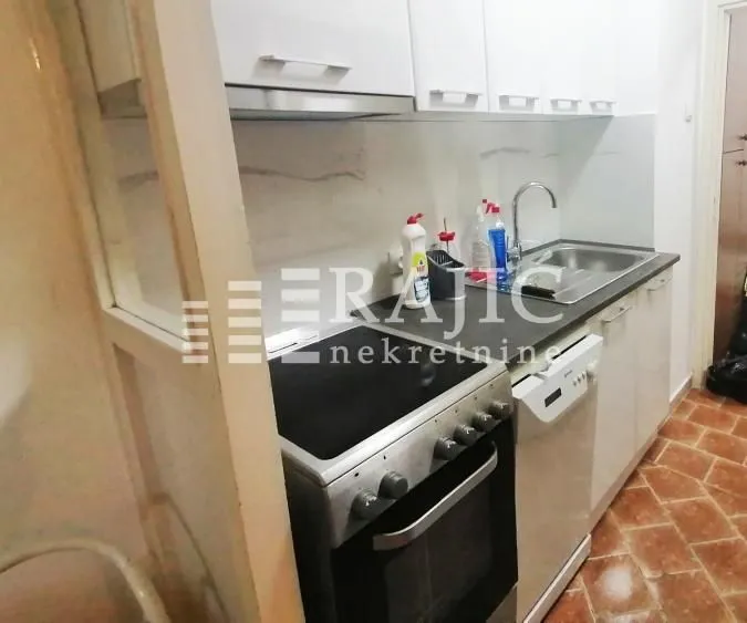 Small kitchen with white cabinets, a stove, and a sink.