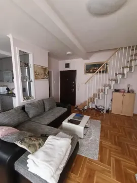 Dnevna soba sa ugaonom garniturom, stočićem i stepeništem koje vodi na sprat. - image 4