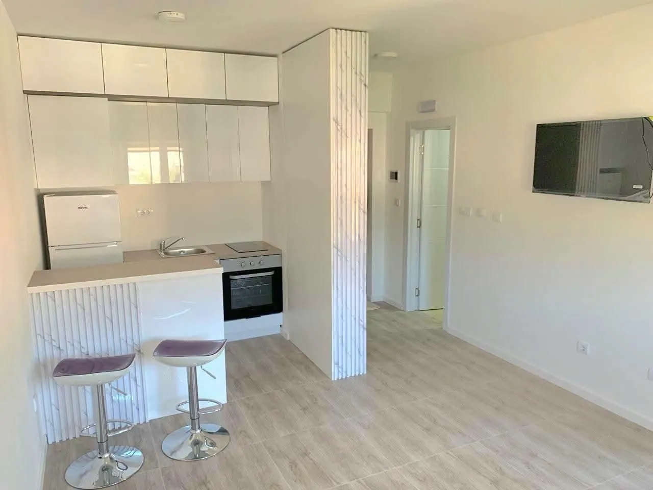 Living room with a kitchen and bar counter.