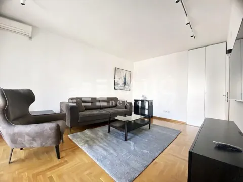 Living room with sofa, coffee table and parquet flooring. - image 2