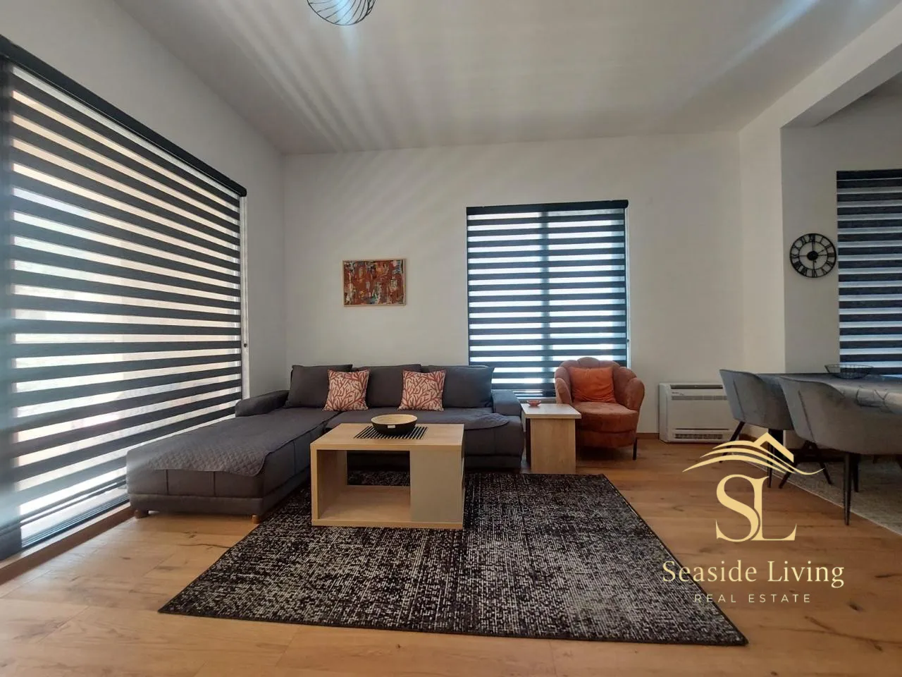 Living room with a sofa, coffee table and dining area.