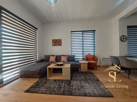 Living room with a sofa, coffee table and dining area. - image 2