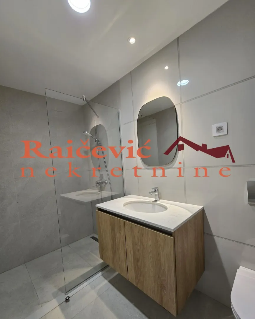 Modernly equipped bathroom with a washbasin and a walk-in shower.