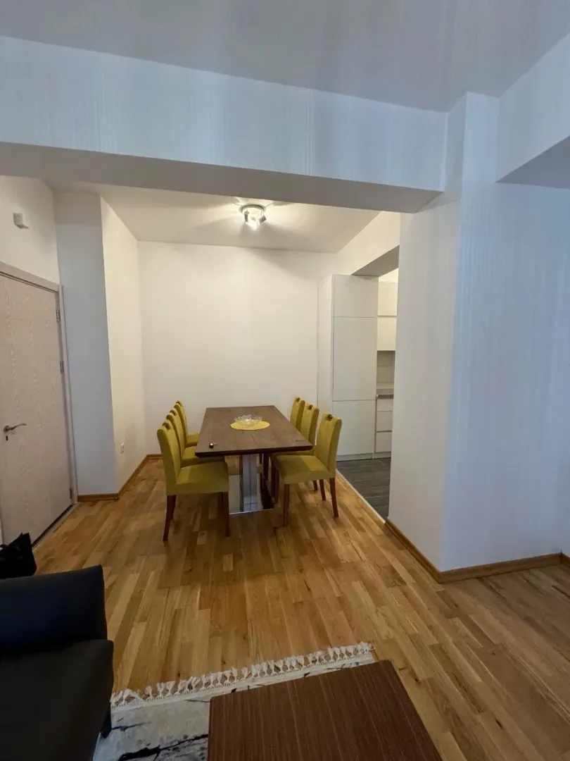 Dining area with a wooden table and yellow chairs.