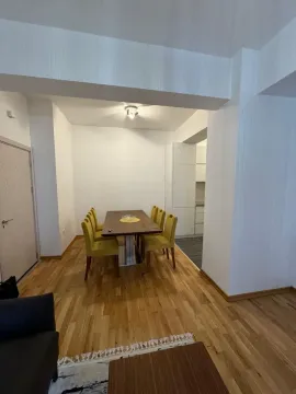 Dining area with a wooden table and yellow chairs. - image 9