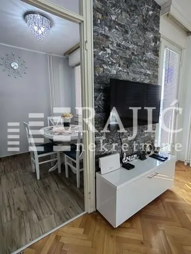 Living room with a TV unit and a view of the dining area.