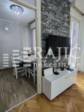Living room with a TV unit and a view of the dining area. - image 6