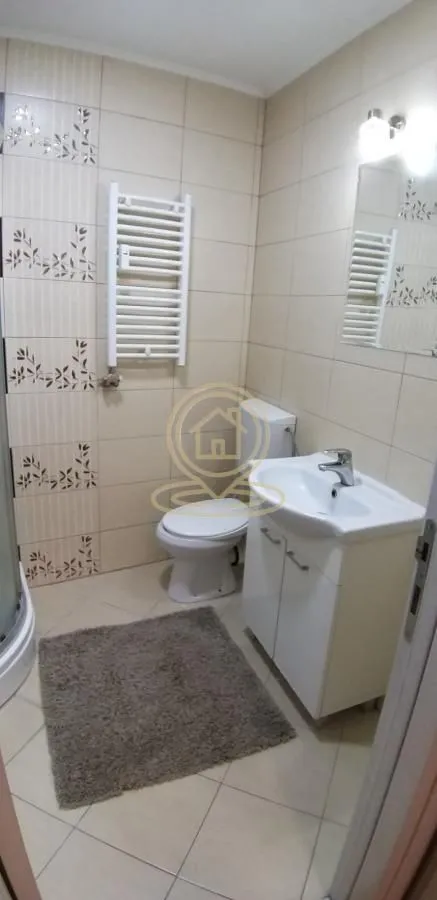 Manje kupatilo sa umivaonikom, WC šoljom i radijatorom za peškire.