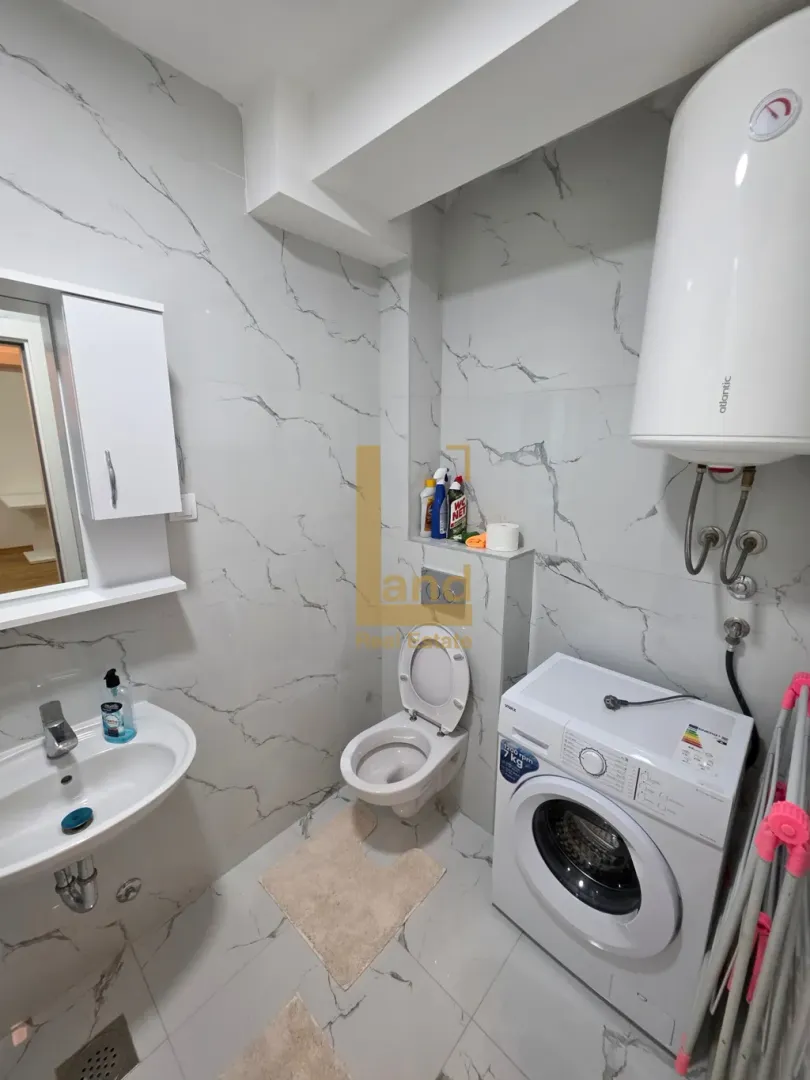 Modernly equipped bathroom with a washing machine.