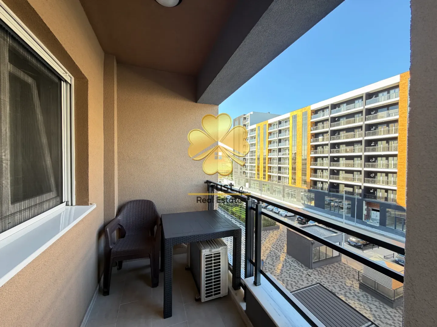 Covered balcony with seating set and a view of the buildings.