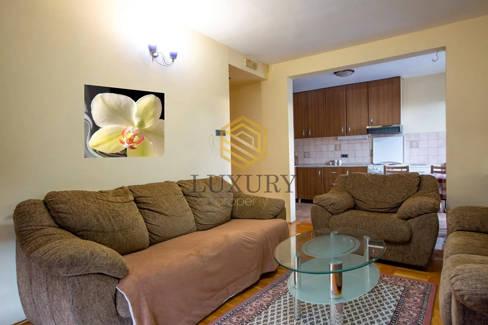 Living room with sofa set and a view of the kitchen.