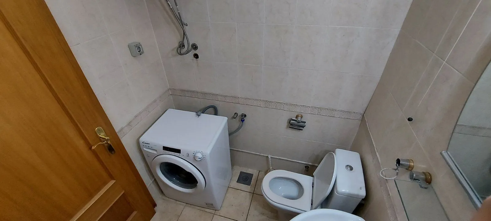 Malo kupatilo sa toaletom i veš mašinom.