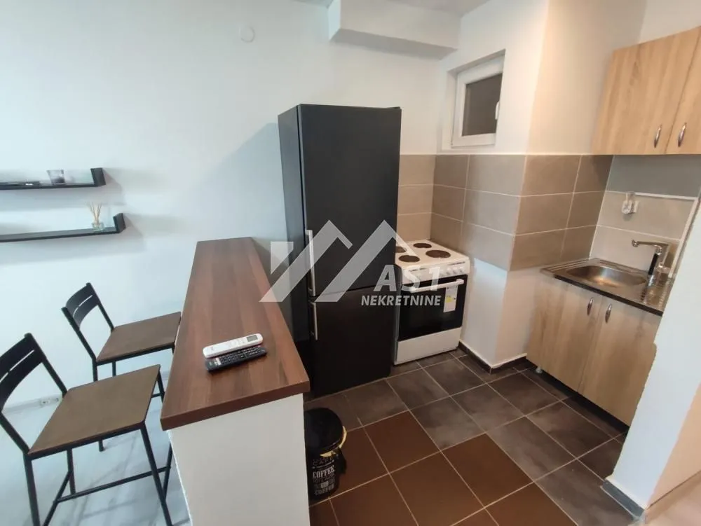 Manja kuhinja sa šankom i trpezarijskim stolicama.