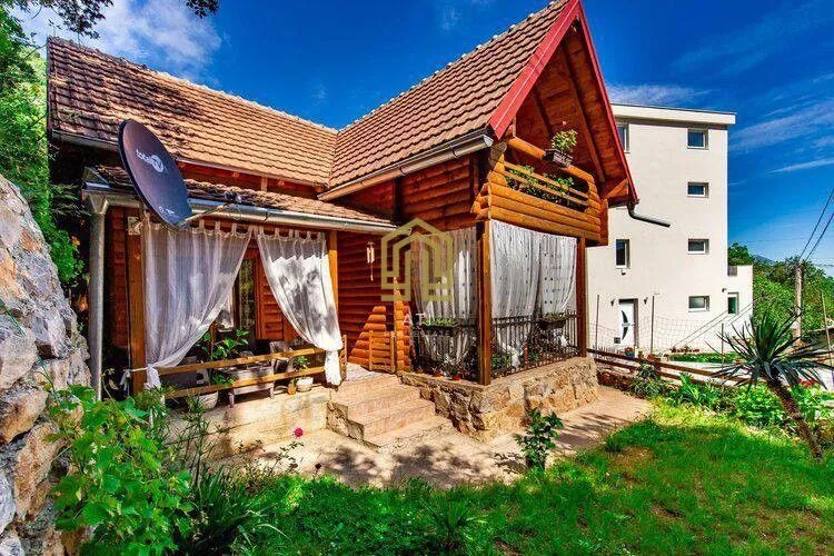 Exterior of a traditional wooden cottage with a landscaped yard.