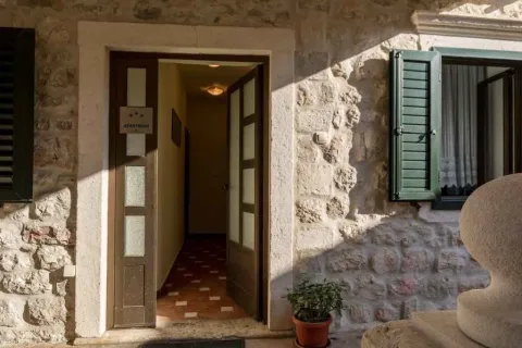 Kameni zid sa ulaznim vratima u apartman i prozorom sa zelenim škurama. - image 18