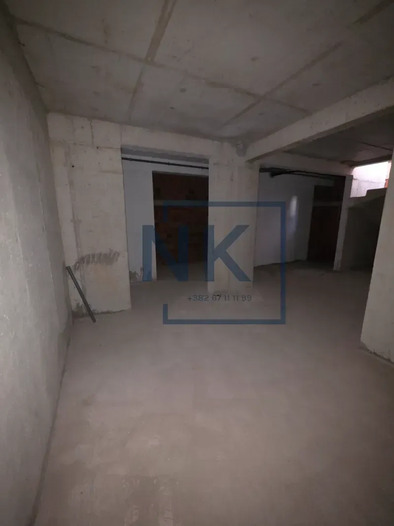 Empty space in rough construction phase with concrete walls and ceiling.