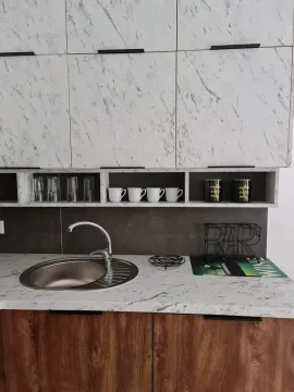 Dio kuhinje sa sudoperom, radnom pločom i gornjim elementima sa dezenom mermera. - image 11