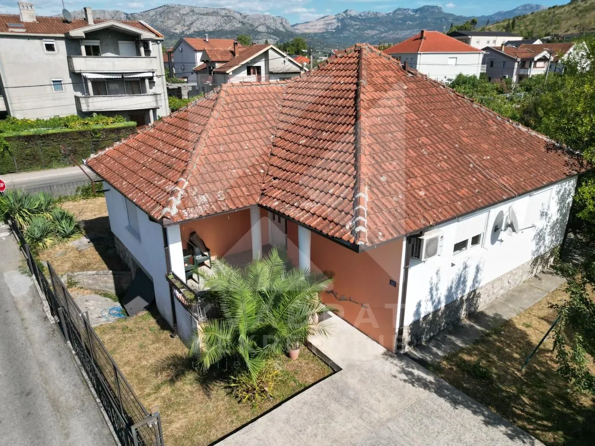 Pogled iz vazduha na kuću sa krovom od crijepa i dvorištem.