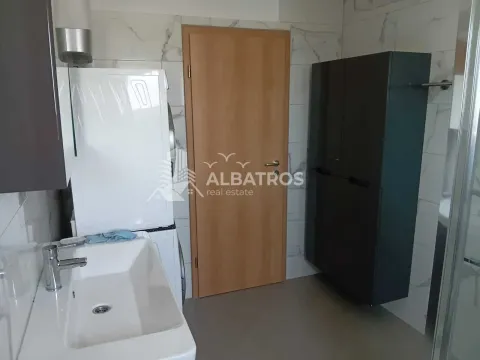 Bathroom with a washbasin, washing machine, and wooden door. - image 13