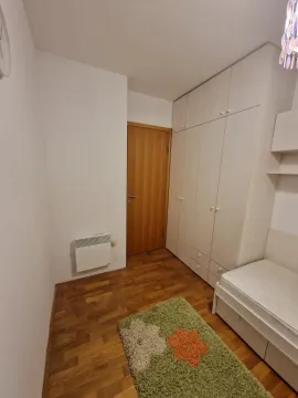 Mala spavaća soba sa jednim krevetom i velikim ugradnim ormarom. - image 13
