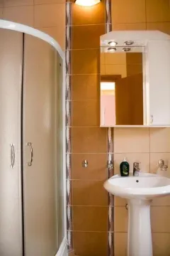 Small bathroom with a shower cabin, washbasin, and mirrored cabinet. - image 6