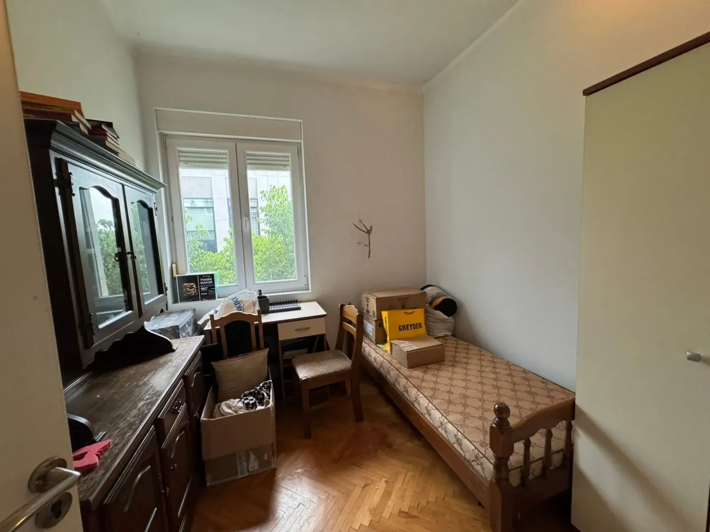 Manja soba sa krevetom, radnim stolom i namještajem.