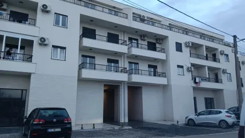 Exterior view of a modern residential building with balconies and parking in front. - image 7