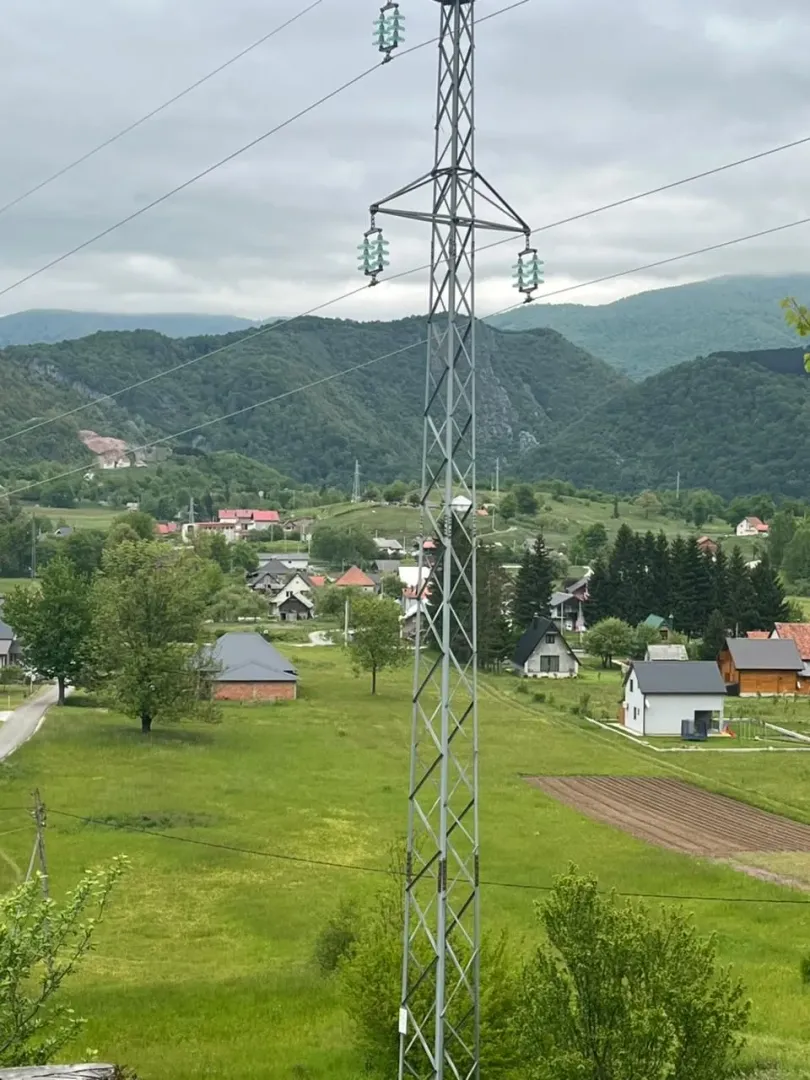 Pogled na seosko imanje sa zelenim površinama i kućama u pozadini.
