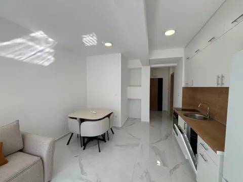 Modern kitchen with dining area and white cabinets. - image 7