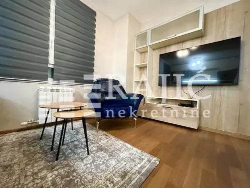 Living room with seating area, TV and coffee table.