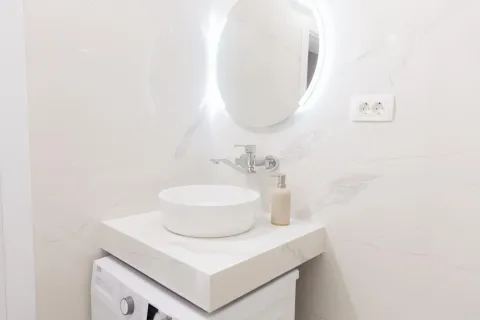 Moderne opremljeno kupatilo sa umivaonikom i okruglim ogledalom. - image 18