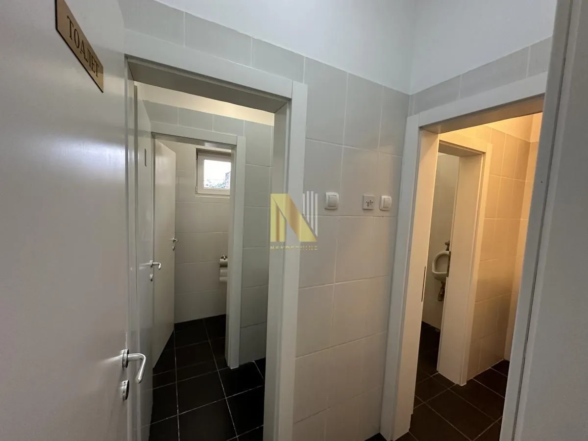 View of the tiled hallway with entrances to the restrooms.