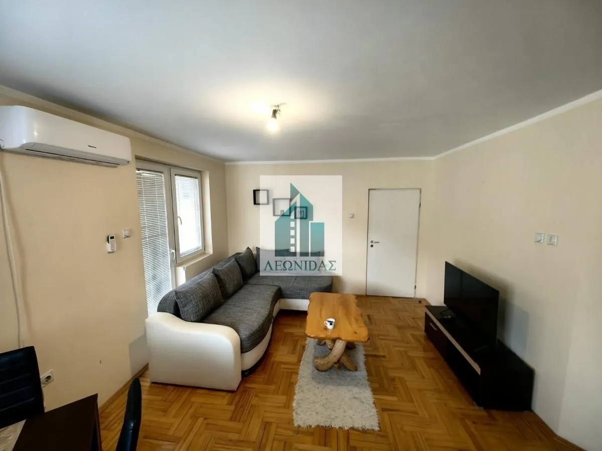 Living room with a sectional sofa, wooden coffee table, and television.