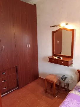 Spavaća soba sa velikim drvenim ormarom, ogledalom i stolčićem. - image 7