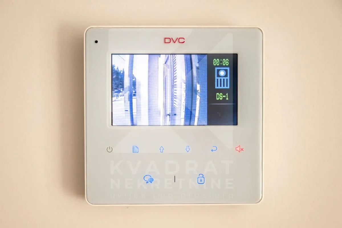 Wall-mounted intercom device with a screen.