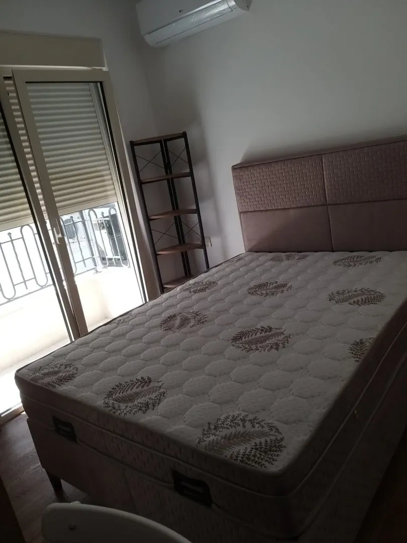 Spavaća soba sa bračnim krevetom i izlazom na terasu.
