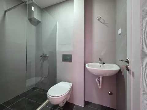 Moderno opremljeno kupatilo sa tuš kabinom, umivaonikom i toaletom u sivim tonovima. - image 9