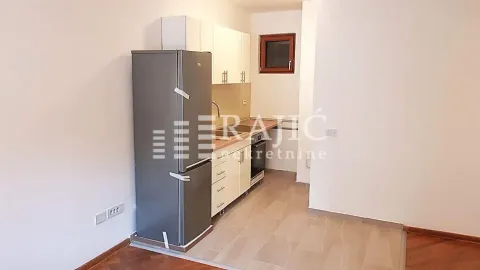 Manja kuhinja sa belim elementima i frižiderom u otvorenom prostoru. - image 7