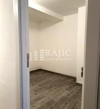 View through the doorway into an unfurnished room with laminate flooring. - image 12