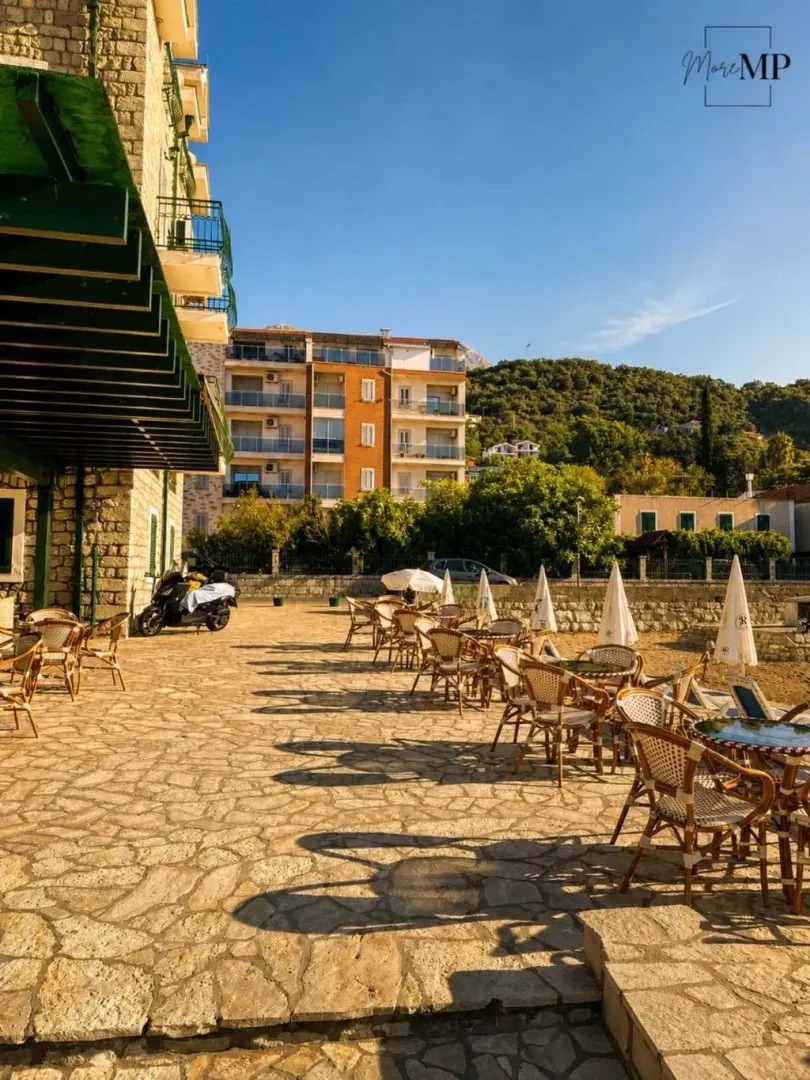 Terasa restorana pored mora sa stolovima i stolicama.