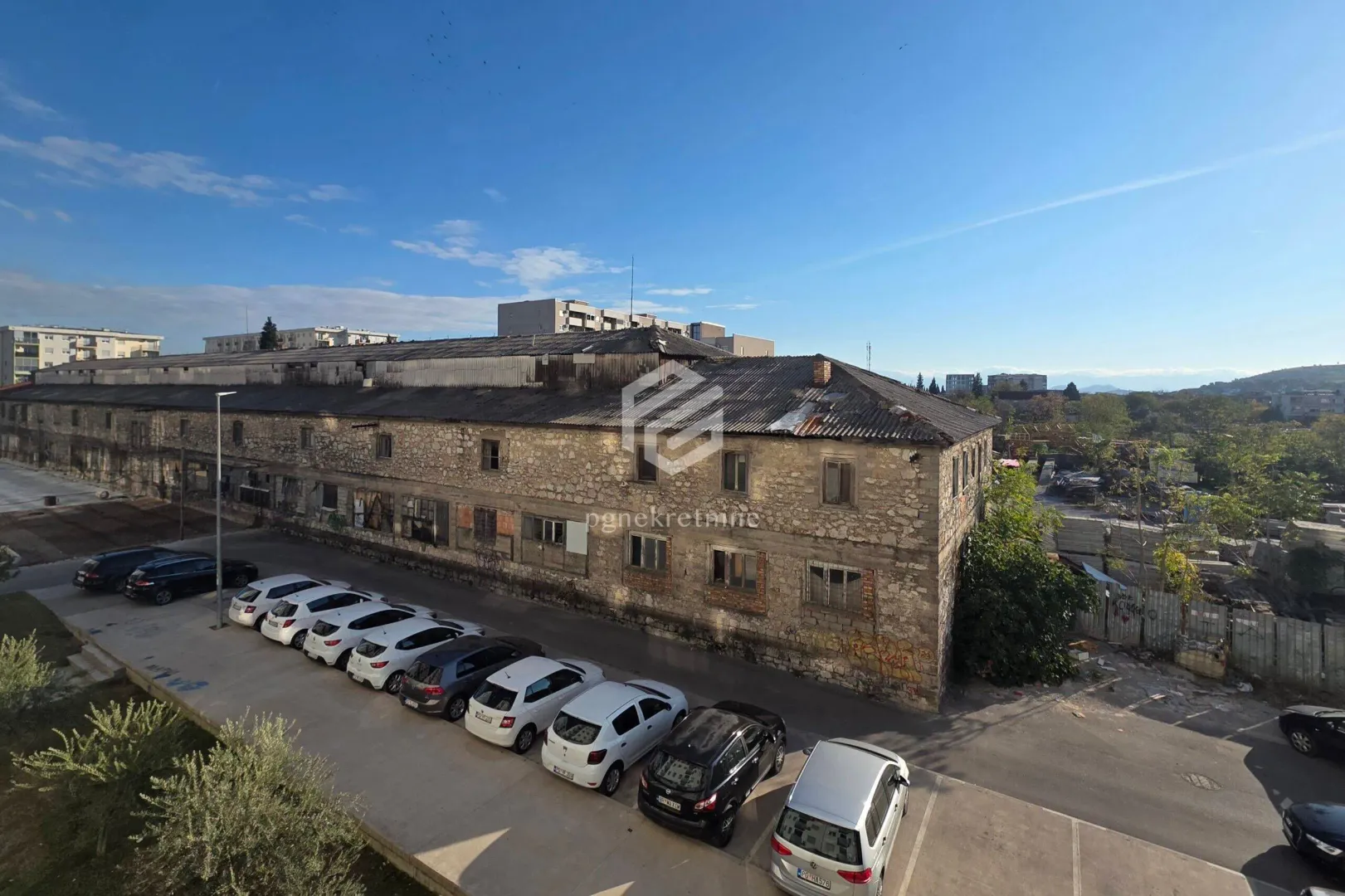 View of the building exterior and parking lot with parked cars.