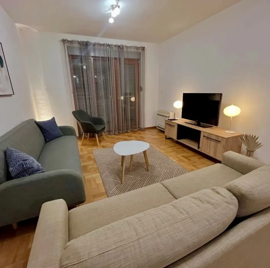 Living room with sofa, TV and coffee table.