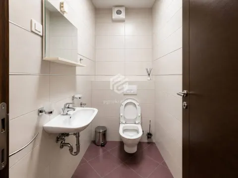 Small bathroom with a sink and toilet tiled in light tiles. - image 14