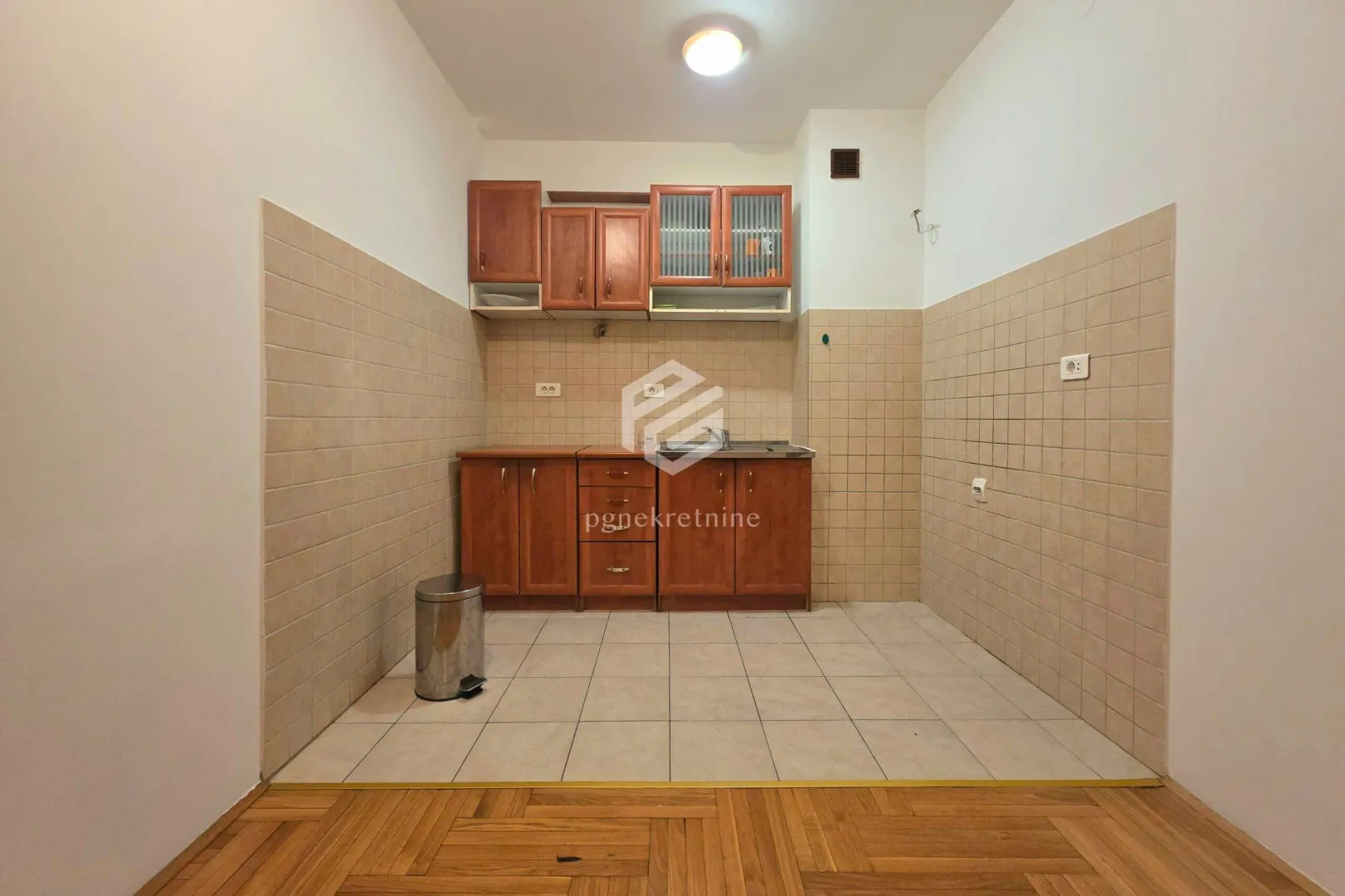 Smaller kitchen with wooden cabinets and ceramic wall tiles.