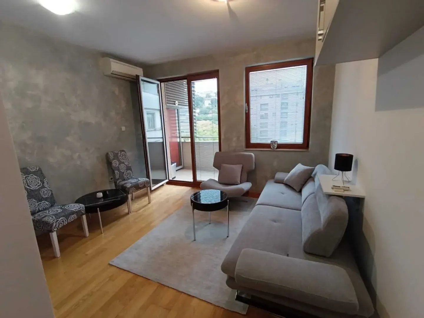 Living room with sofa, armchairs and access to the balcony.