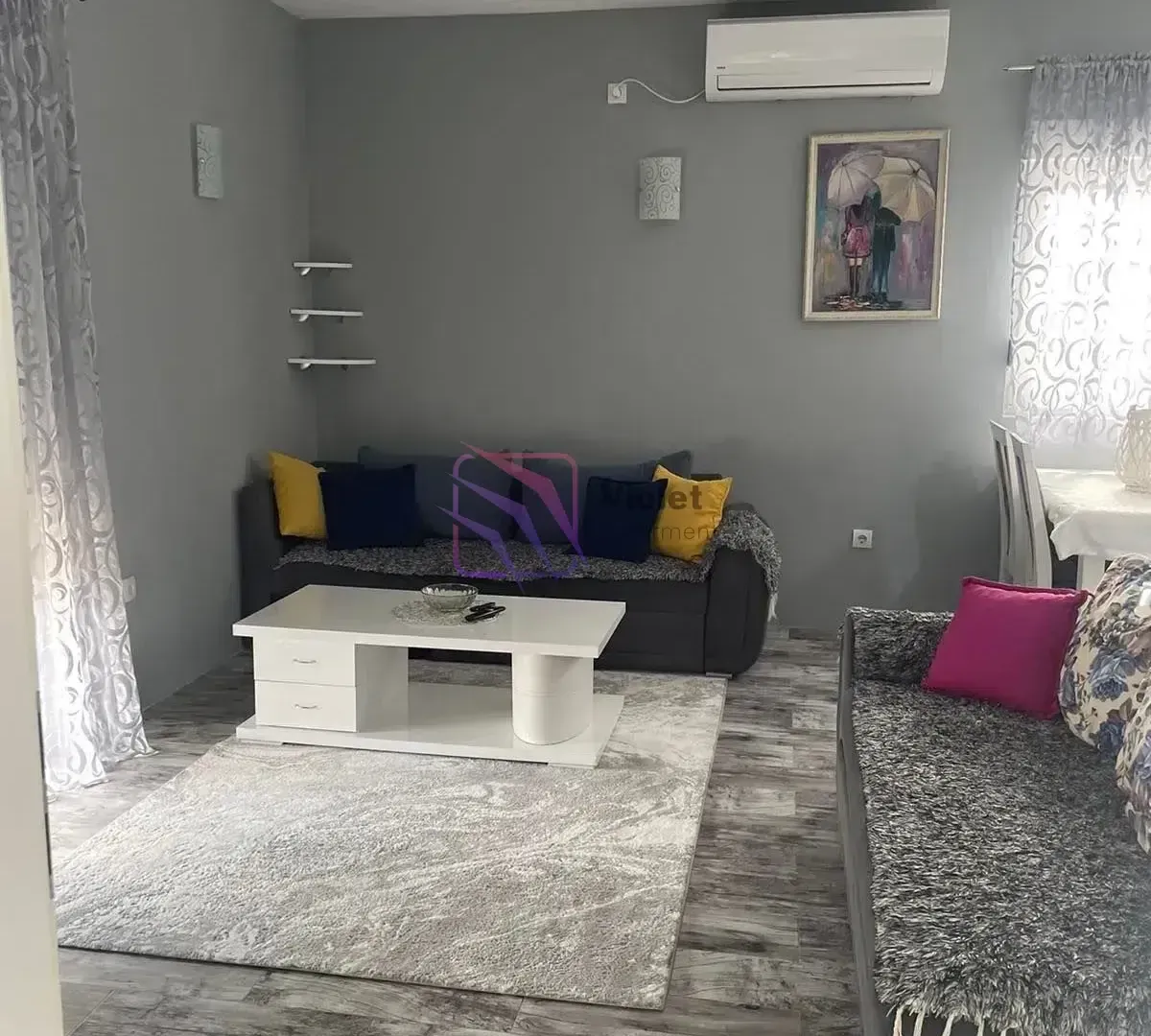 Living room with a sofa set, coffee table, and air conditioning unit.