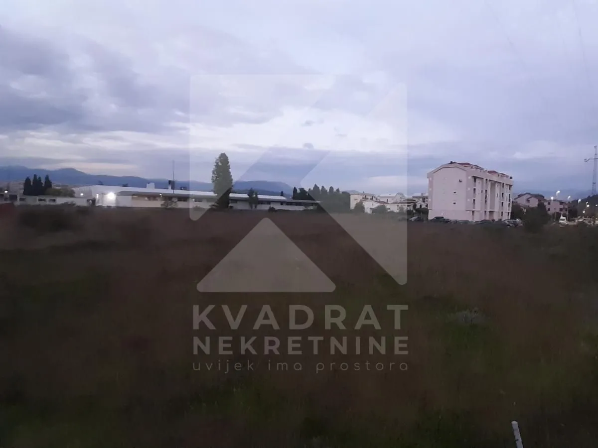 Pogled na zemljište i okolne zgrade u sumrak.